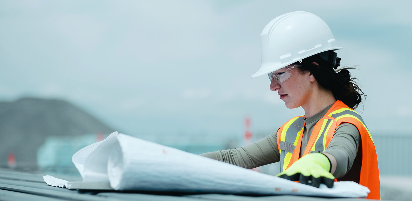 Professionnelle sur un chantier consultant des plans.