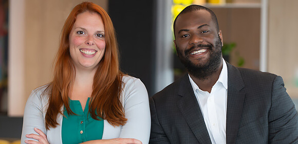 Two FlexiFonds advisors smile at the camera.