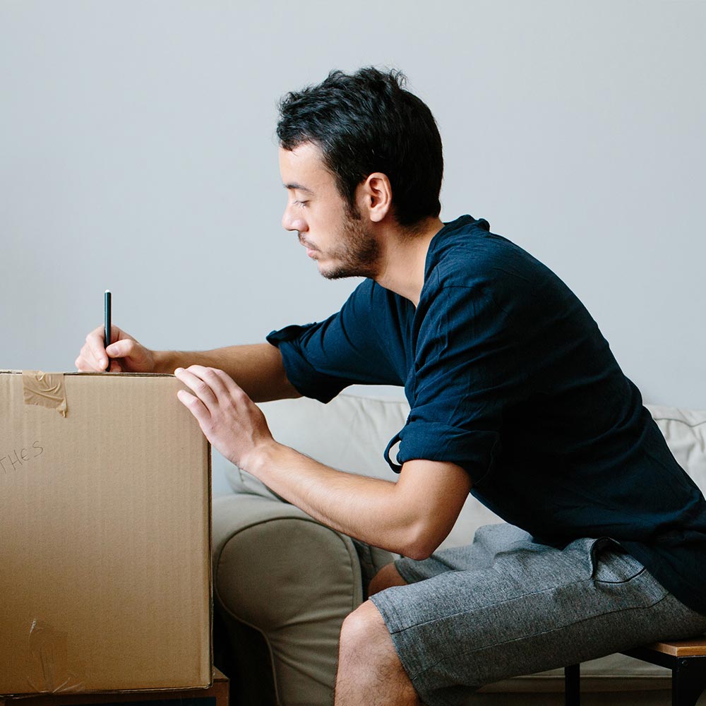 Homme assis parmi des boîtes